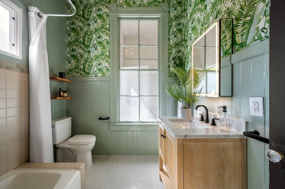 Bathroom with botanical wallpaper and wood vanity