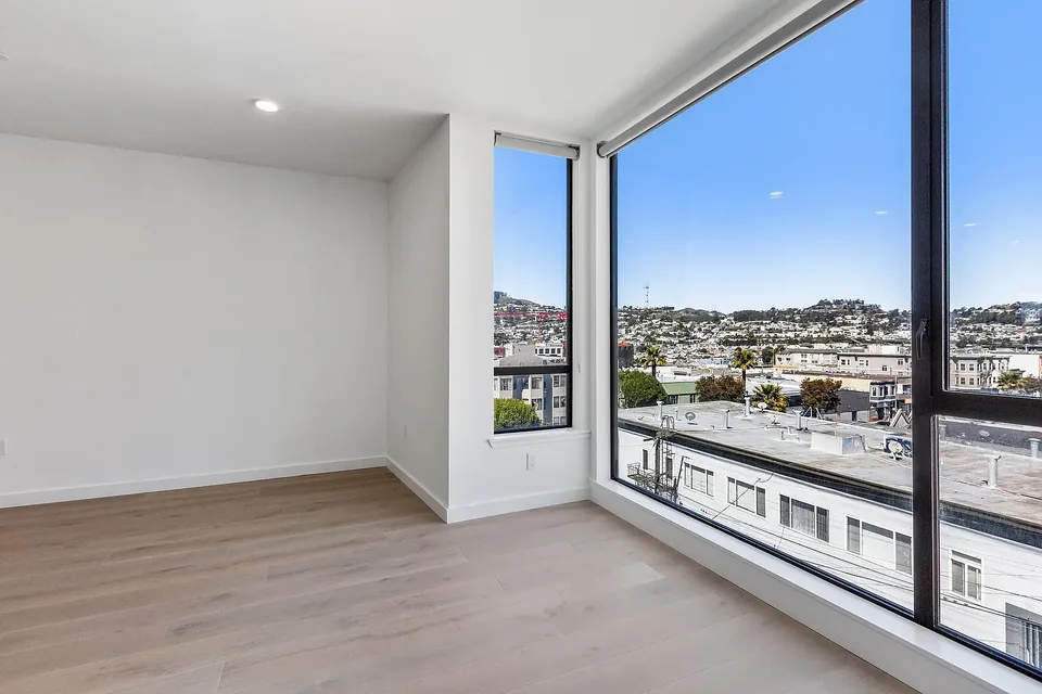 Corner room with floor-to-ceiling windows and hillside views