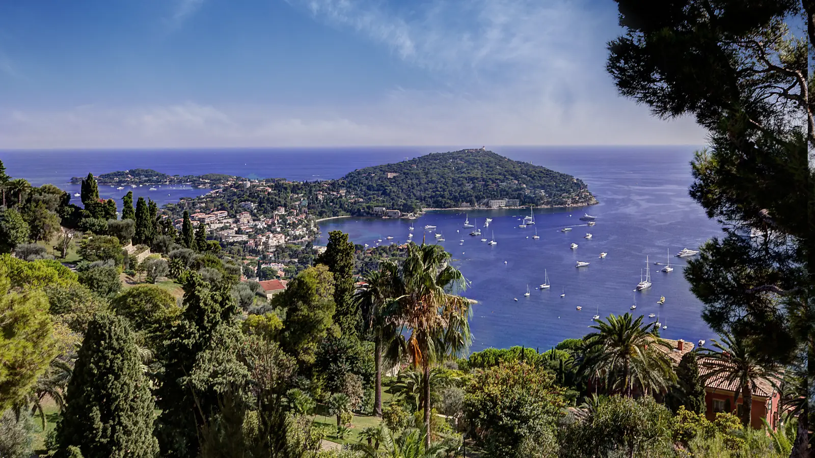 Cap Ferrat and the bay seen through cypress and pine trees