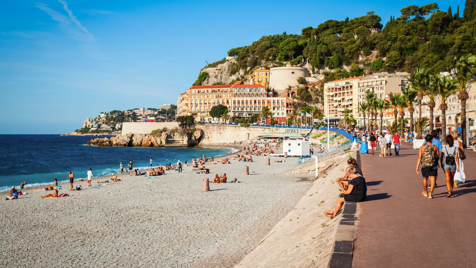 The Promenade des Anglais and the pebble beach in Nice, with Castle Hill rising behind