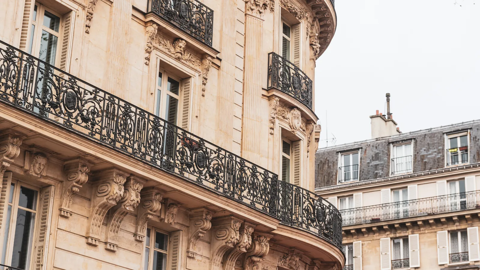 Ornate wrought-iron balconies on a Haussmann apartment building in Paris