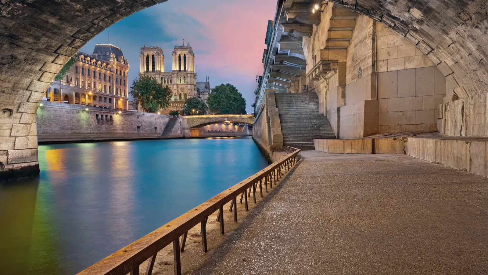 The Seine quay in Paris, seen from beneath a stone bridge