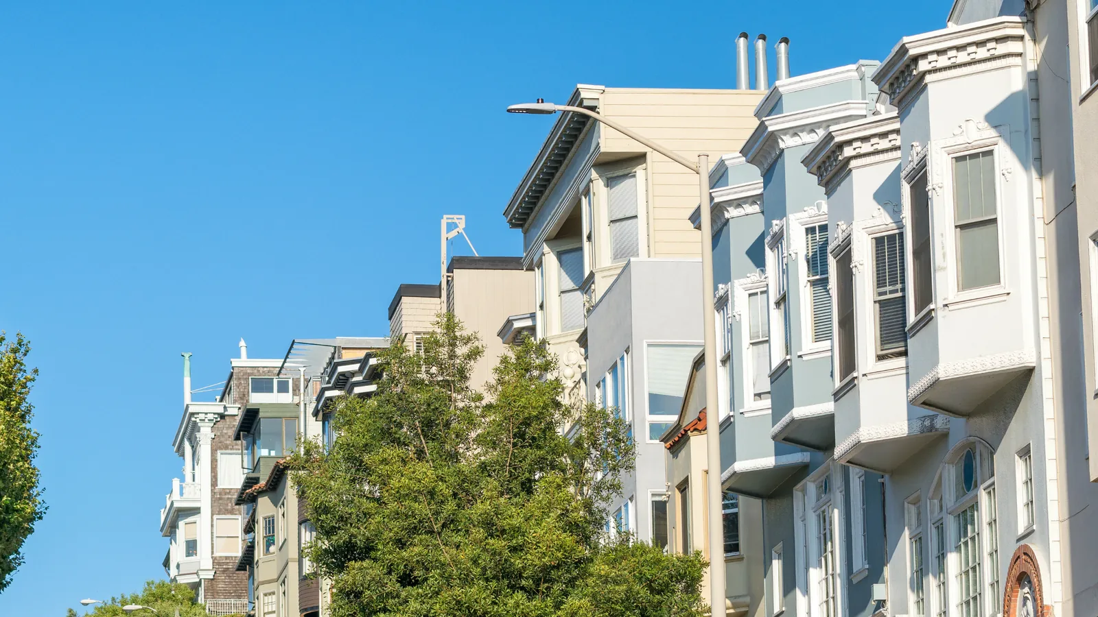 A row of Edwardian flats with stacked bay windows on a San Francisco street