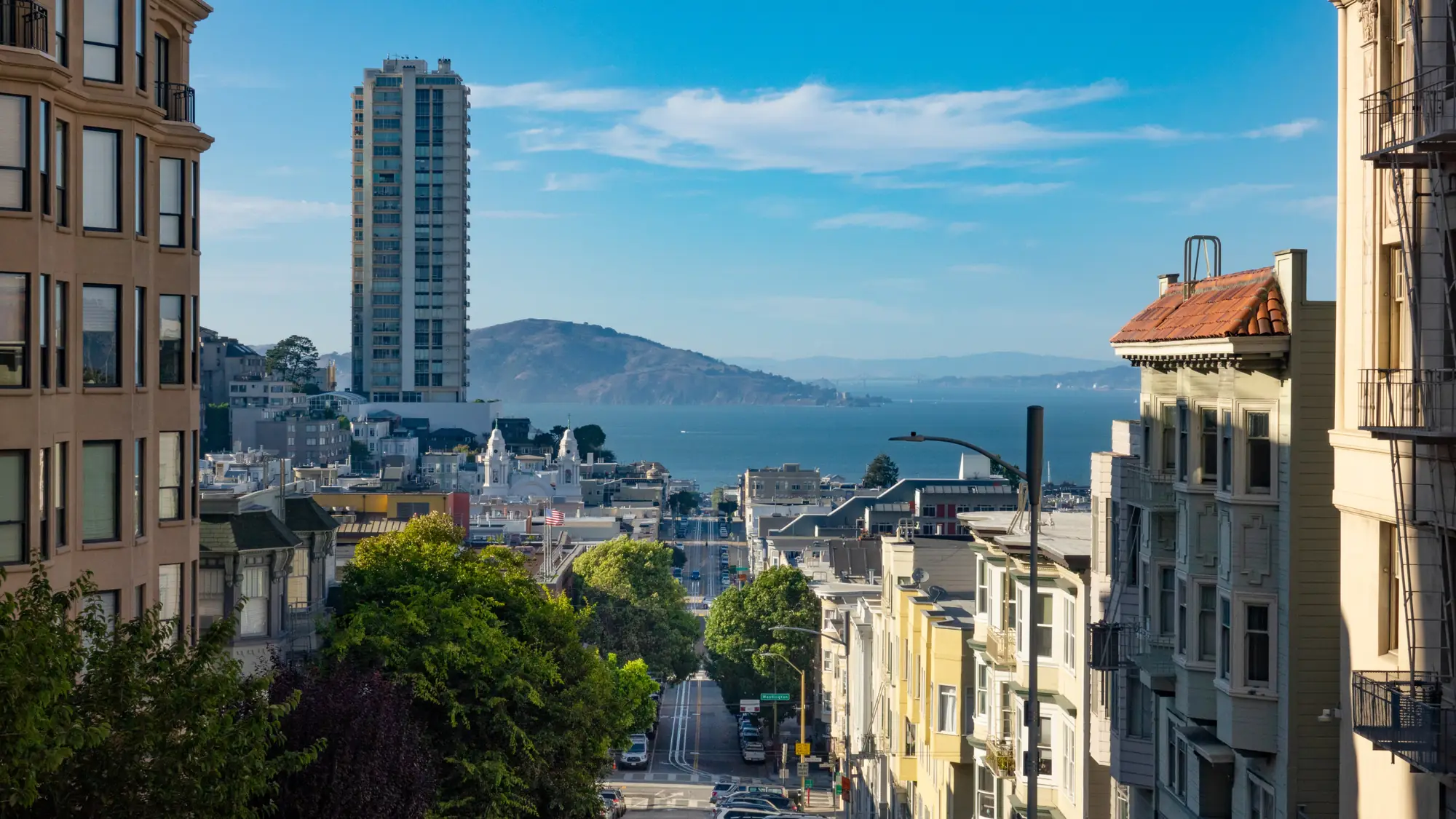 A San Francisco street descending toward the bay, with Angel Island in the distance