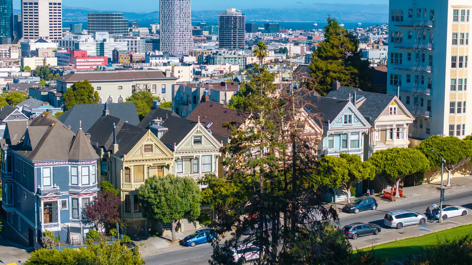 Victorian homes and apartment buildings in San Francisco, with downtown behind